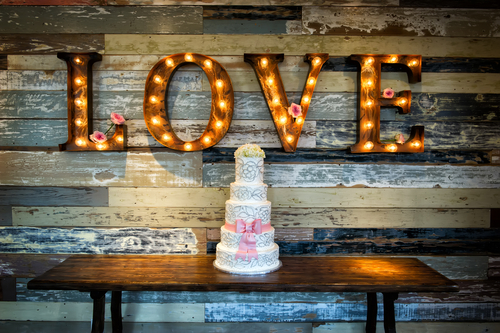 A wedding cake and a love sign at a wedding reception